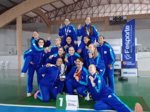 Pienense junto ao treinador e companheiras de equipe. Foto: Arquivo Pessoal